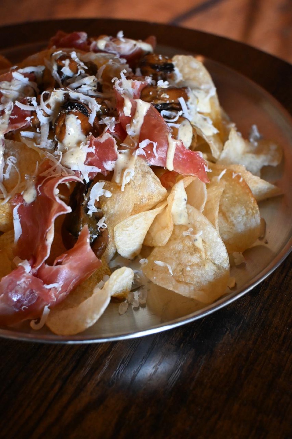 Papas fritas con jamón, mejillones y queso rallado